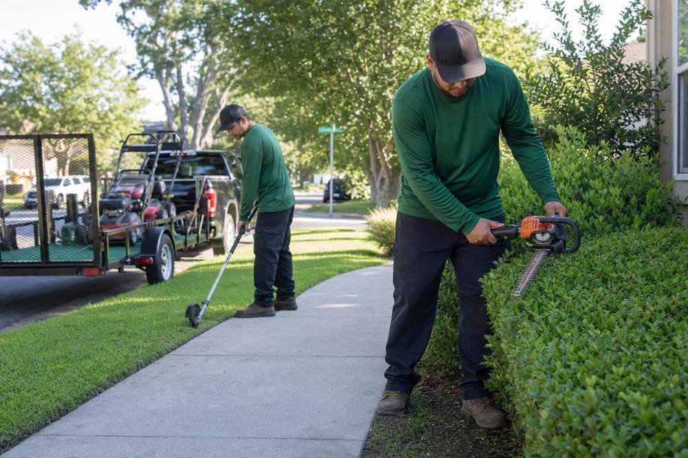 A lawn crew working in a front yard.